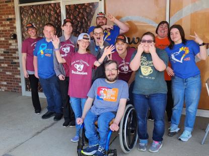 group of 11 young adults smiling and waving
